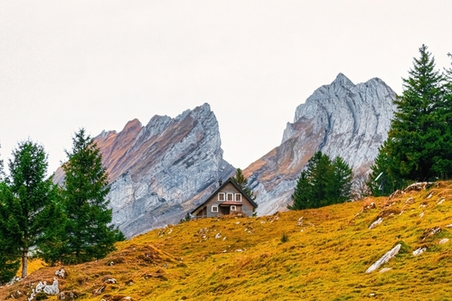 View of the Santis Mountain on a cloudy day with a chalet below, Canton of Appenzell, Switzerland
