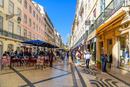 The popular Rua Augusta street, full of shoppers and diners enjoying the stores, restaurants and sidewalk cafes and calçada pavement in the Baixa District, Lisbon, Portugal