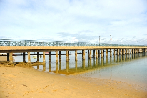 aro beach and the bridge connecting to town, Faro, Algarve, Portugal