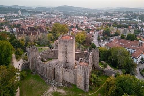 Aerial views of Guimaraes Castle. Cityscape seen from the air at sunset, Guimaraes, Portugal