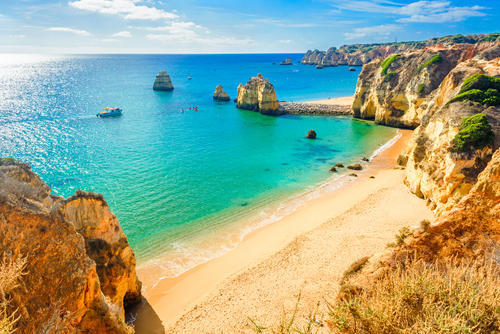 Praia de Dona Ana beach with turquoise sea water and cliffs, Portugal. Beautiful Dona Ana Beach (Praia Dona Ana) in Lagos, Algarve, Portugal. Learn about attractions in Lagos in thetjoy.com.
