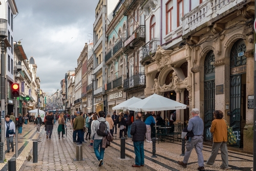 Downtown of Porto city. Main shopping street of Porto. People walking. At left is Continente Bom Dia Via Shopping Center, Portugal