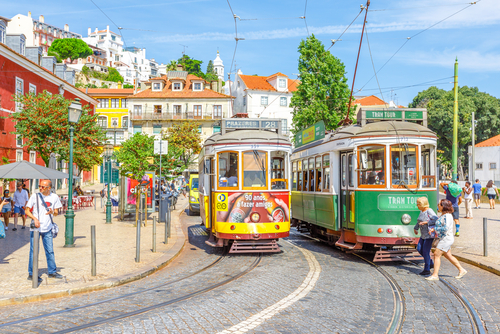 New Tram Tour and famous vintage yellow Tram 28 near Portas do Sol viewpoint in historic Alfama District, an icon of the Portuguese capital, Lisbon, Portugal